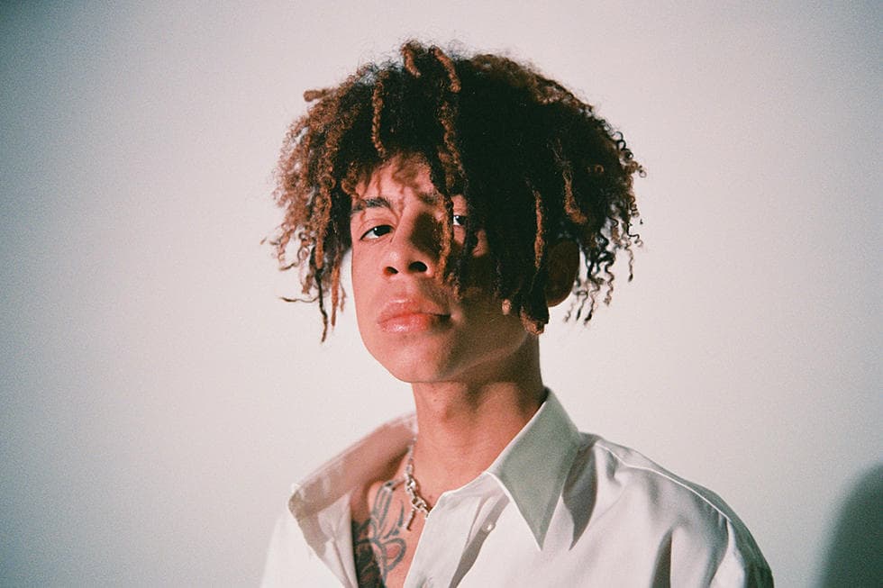 Headshot of the young rapper Iann Dior wearing a white shirt